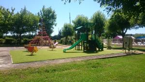 une aire de jeux avec toboggan et arbre dans un parc dans l'établissement Camping Paradis le Rocher de la Granelle, au Bugue