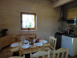a kitchen with a wooden table with chairs and a dining room at Agroturystyka nad Morzem in Ustka