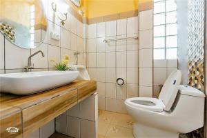 a bathroom with a white toilet and a sink at Baandin Chiewlarn in Ban Tha Khun