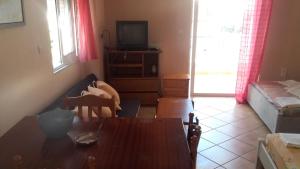 a living room with a table and a television at Chris Apartment in Preveza