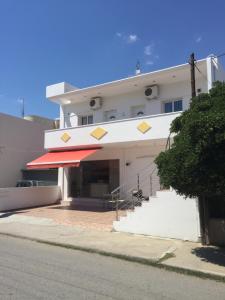 a large white building with a red awning at Mythagogia Luxury House in Archangelos