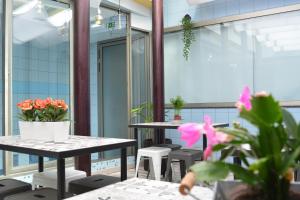 a room with tables and chairs and flowers at World n'Porto Hostel in Porto