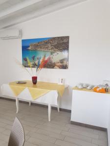 een eetkamer met een tafel en een schilderij aan de muur bij Villa Mattia in Lampedusa