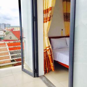 a room with a bed and a glass door with a window at Thanh Dat 2 Hotel in Vinh