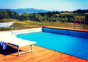 a swimming pool with a white chair and a table at Casale Molinelle in San Gemini