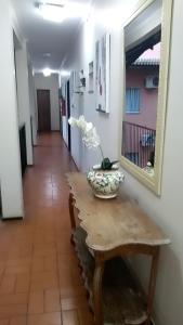 a table with a vase on it with a mirror at Hotel Charme Fonte do Boi in Salvador