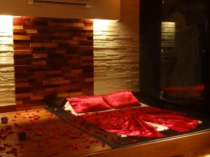 Una cama con sábanas rojas y almohadas rojas. en Delirio Moteis Pousada en Dourados