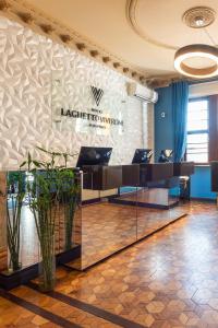 a lobby of a hotel with a sign on a wall at Hotel Laghetto Moinhos in Porto Alegre