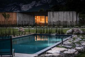 une piscine dans un jardin avec une maison dans l'établissement Agritur La Dolce Mela - Adults Only, à Vezzano