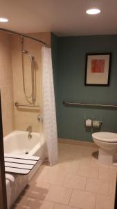 a bathroom with a shower and a tub and a toilet at Hyatt Place Fort Myers at the Forum in Fort Myers