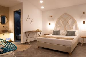 a bedroom with a large bed and a bathroom at Vintage Suites in Limenaria
