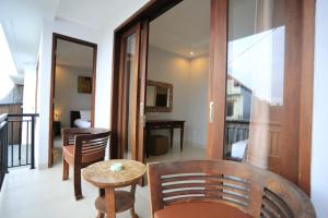 ein Wohnzimmer mit Tisch und Stühlen und einem Balkon in der Unterkunft Nyoman Villa Sanur in Sanur