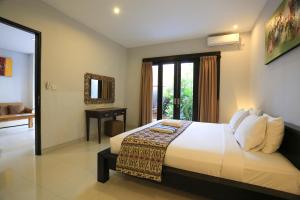 ein Schlafzimmer mit einem Bett und einem Schreibtisch in einem Zimmer in der Unterkunft Nyoman Villa Sanur in Sanur