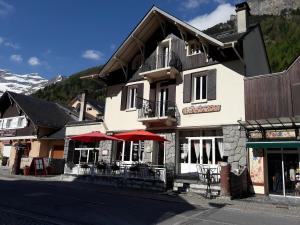 a building with tables and umbrellas in front of it at Chambres d'hôtes L'Astazou in Gavarnie