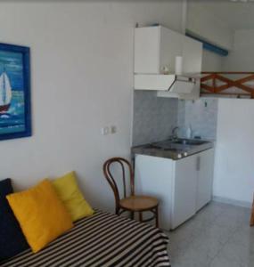 a small kitchen with a bed and a sink in a room at Studio in Poros in Poros