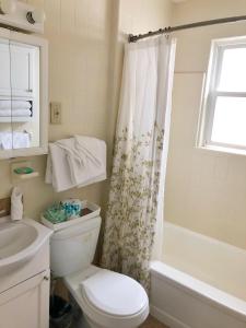 a white bathroom with a toilet and a shower at Sea Kist Motel in Wildwood