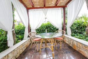 a patio with a glass table and chairs at Apartments Finida in Poreč