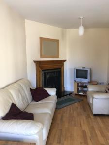 a living room with a white couch and a fireplace at O'Connors Guesthouse in Faha