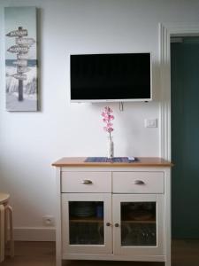 a white cabinet with a television on a wall at Boulevard de la Mer 33 Apartam 11 in Hendaye