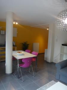 Appartement rez Terrasse et Jardin في هوي: غرفة معيشة مع طاولة وكراسي أرجوانية