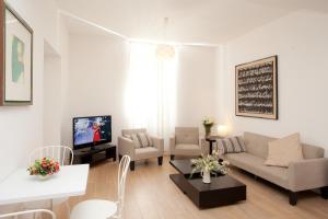 a living room with a couch and a tv at Hotel Lydia in Alassio