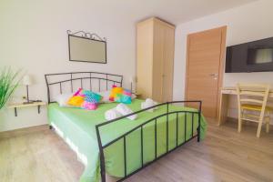 een slaapkamer met een groen bed met kleurrijke kussens bij Apartments Nicole in Pula
