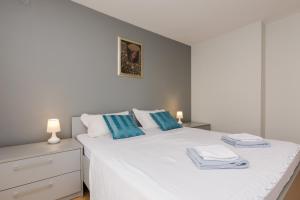 um quarto com uma cama branca e almofadas azuis em Barita em Zadar
