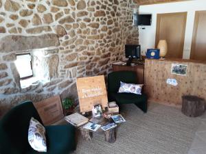um quarto com duas cadeiras, uma mesa e uma parede de pedra em Cidadelhe Rupestre Turismo Rural em Cidadelhe