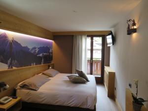 um quarto com uma cama com uma fotografia na parede em Hotel Compagnoni em Santa Caterina di Valfurva