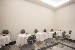 a room with tables and chairs with white table cloth at Albergo del Golfo in Naples