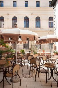 an outdoor patio with tables and chairs and a building at Albergo del Golfo in Naples