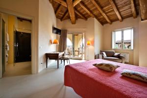 ein Schlafzimmer mit einem roten Bett und ein Wohnzimmer in der Unterkunft Agriturismo Pratello in Padenghe sul Garda