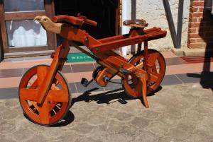 un vélo orange garé sur le côté d'un bâtiment dans l'établissement Appartements d'Hôtes Marciloui, à Antsirabe