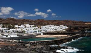 GuatizaにあるCasa Helena del Marの白い建物と海の景色を望むビーチの景色