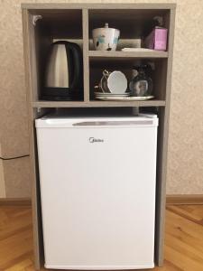 a white refrigerator in a cabinet with a shelf at Guest House Rafael in Tbilisi City