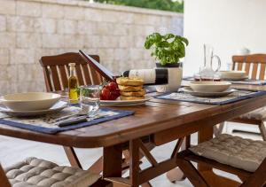 un tavolo in legno con piatti di cibo sopra di Dimora Smeraldo a Marina di Mancaversa