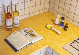 マリーナ・ディ・マンカヴェルサにあるDimora Smeraldoのワインの入ったキッチンカウンターのオープンブック