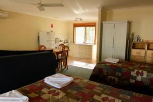 a living room with two beds and a kitchen at Travellers Rest Motel in Mundaring