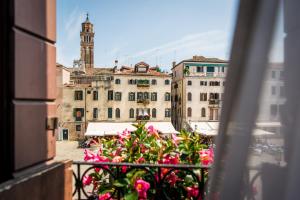 a view of a city from a balcony with pink flowers at Hotel Santo Stefano in Venice