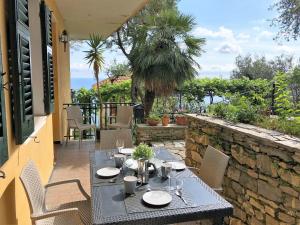 una mesa y sillas en un patio en House Levante by Holiday World, en Pieve Ligure