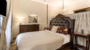 a bedroom with a bed and a dresser and a mirror at Exclusive Royal Apartments in Krakow