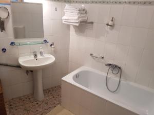 a white bathroom with a sink and a bath tub and a sink at Santino Apartment in Sibiu +13 photos