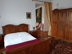 a bedroom with a bed and a chair in it at Santino Apartment in Sibiu