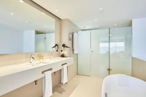
a bathroom with a tub, sink and mirror at Eurostars Ibiza in Ibiza Town
