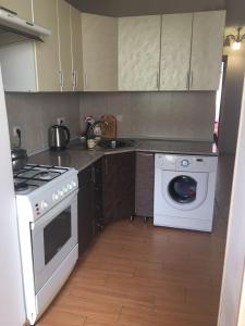 a kitchen with a stove and a washing machine at Apartment on Lakoba 60 in Novy Afon