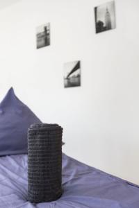 a bed with purple sheets and pictures on the wall at AVR Apartment Geestemunde in Bremerhaven