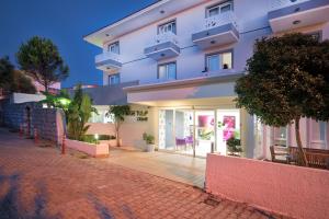 a white apartment building with a brick road at Ege Tulip Cesme in Cesme