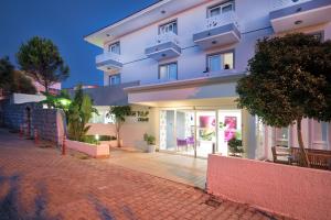 a white apartment building with a brick road at Ege Tulip Cesme in Çeşme