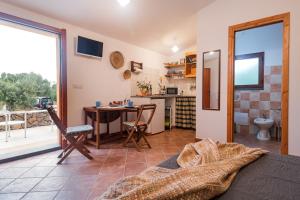 a living room with a table and a kitchen at S'Ulumu in Dorgali