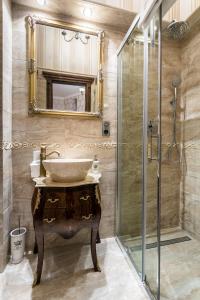 bagno con lavandino e doccia in vetro di Exclusive Royal Apartments a Cracovia